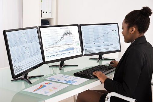 office worker using multiple monitors to work